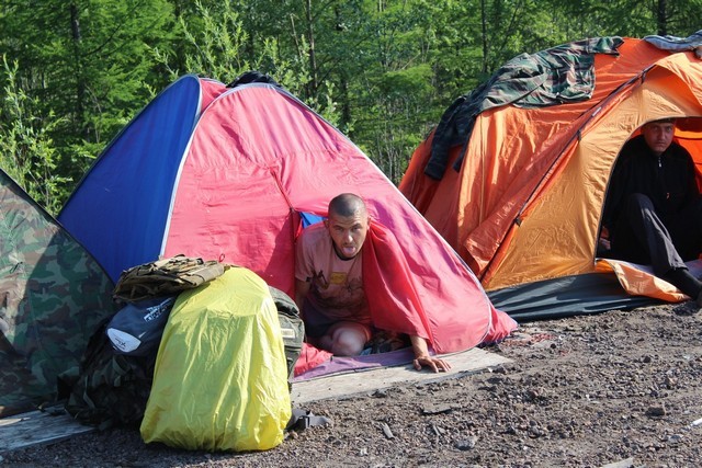 вылезает из палатки